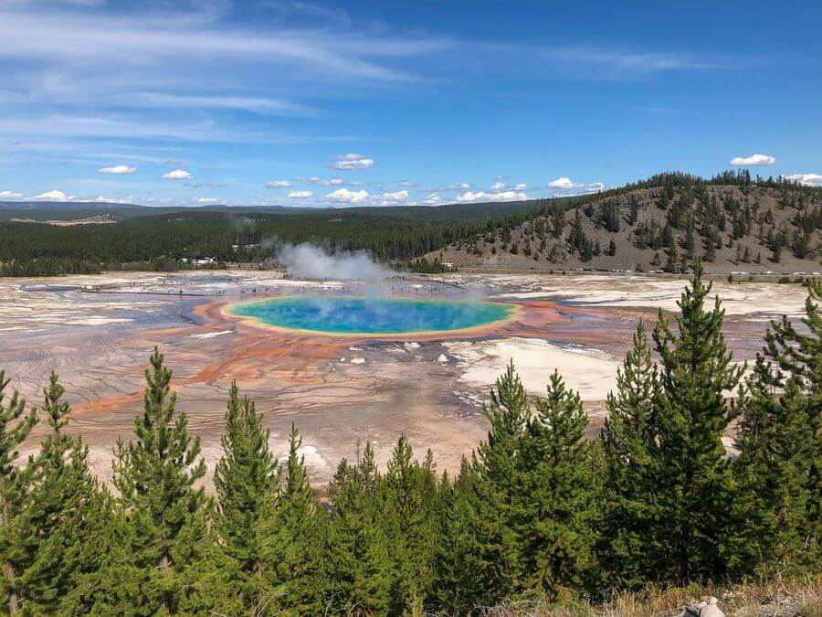 The blue/green Grand Prismatic Hot Spring in Yellowstone National Park, ringed with layers of yellow and red as seen from above