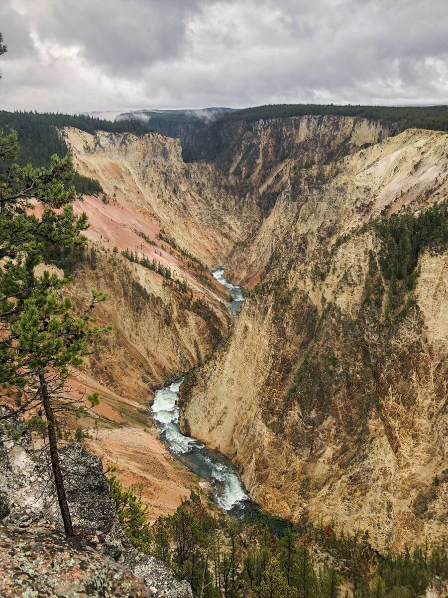 A deep, richly colored canyon carved by the river at the very bottom with numerous white rapids