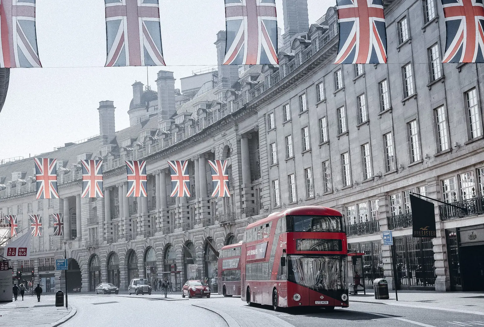 Red double decker bus on Regent Street under Union Jack flags