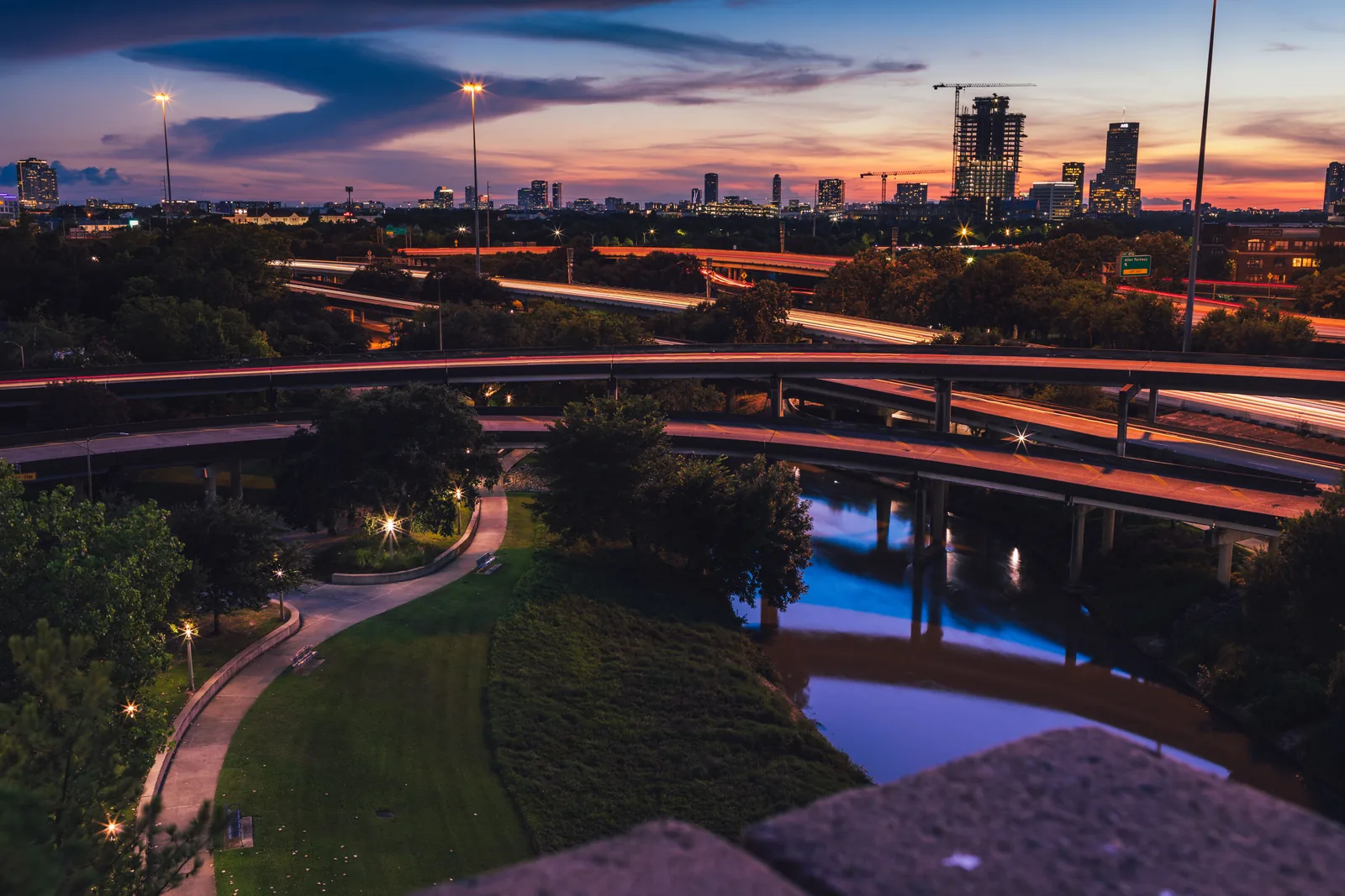 Buffalo Bayou Park winding below the Houston skyline at sunset