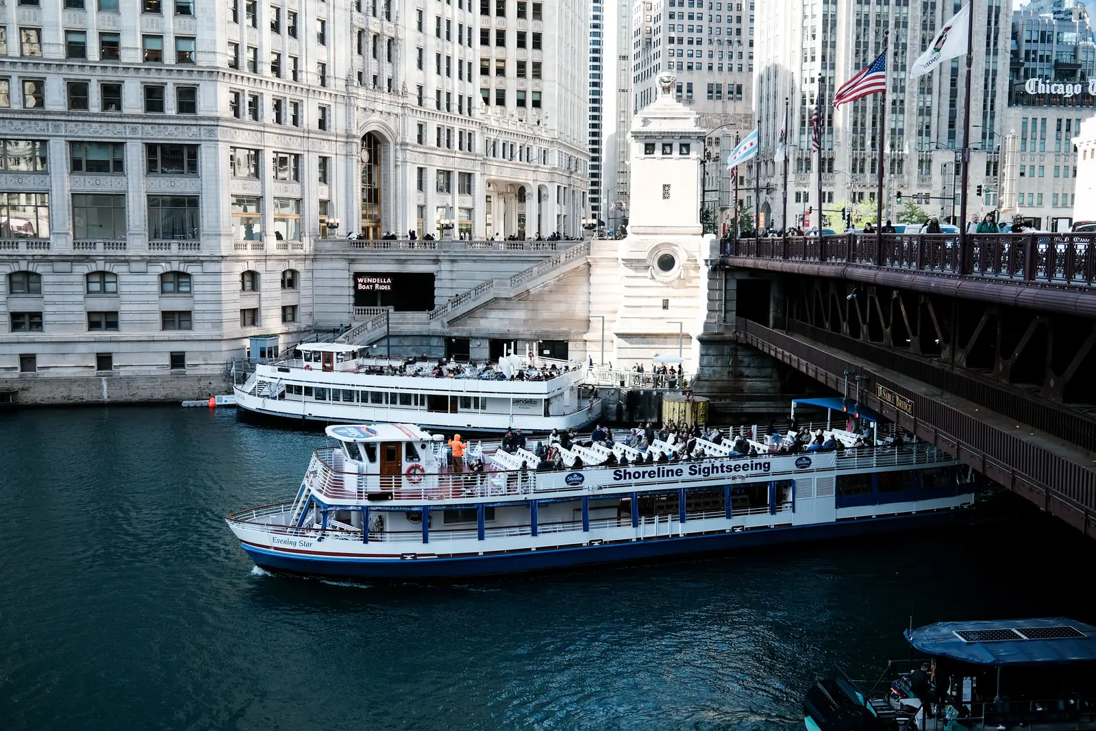 An architecture tour boat on the Chicago River between skyscrapers