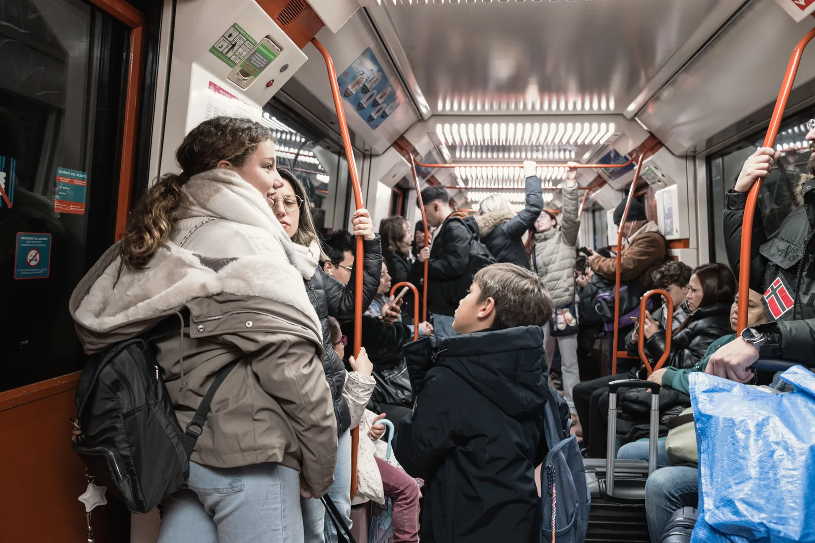 Commuters standing shoulder to shoulder inside a crowded metro train