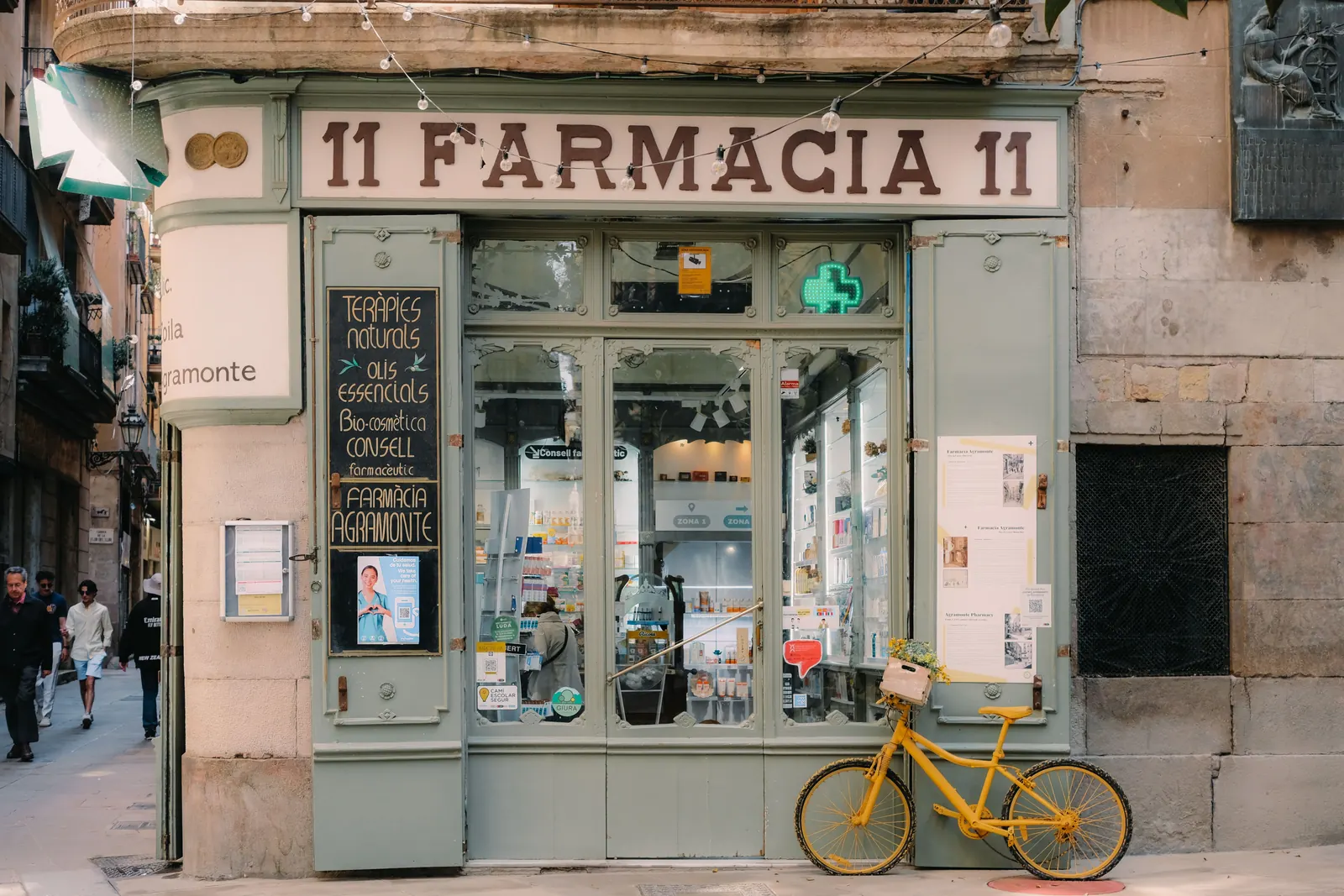A pharmacy storefront with a bicycle parked outside in Barcelona