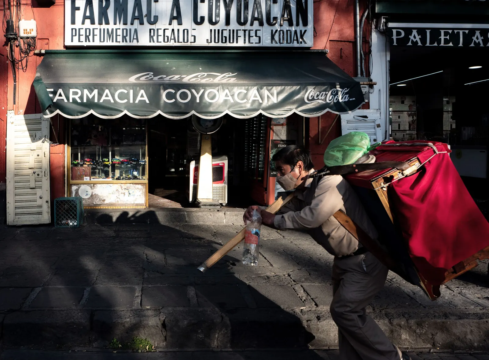 A man walking past a pharmacy in Mexico City