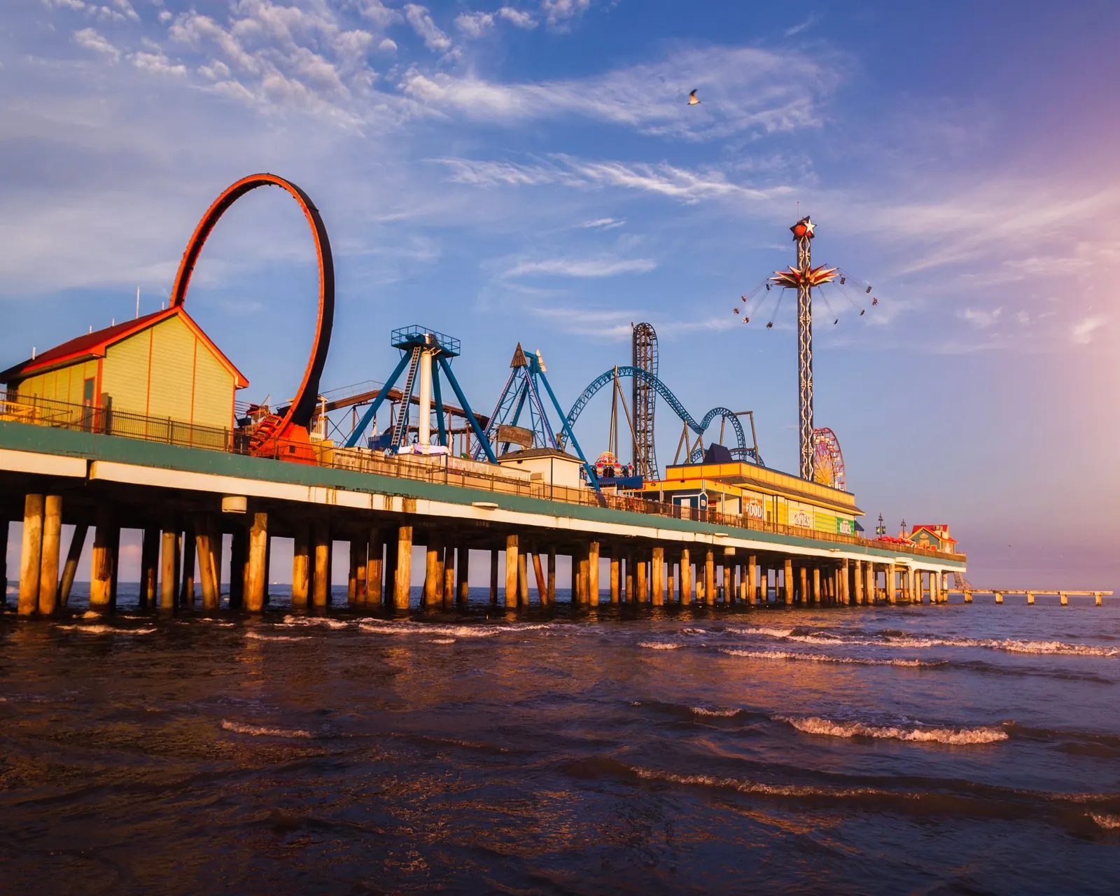 The Galveston Island Historic Pleasure Pier and its roller coaster at sunset