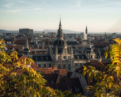 Golden evening light over the domes, spires, and red rooftops of Graz, Austria