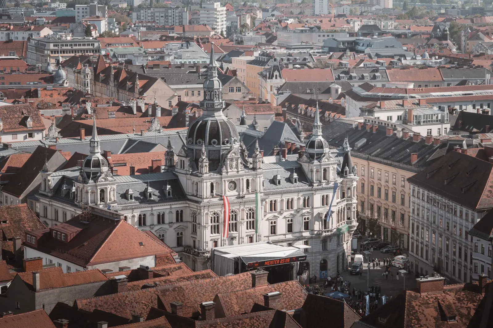 The domed town hall on Hauptplatz in Graz seen from above, surrounded by red tile roofs