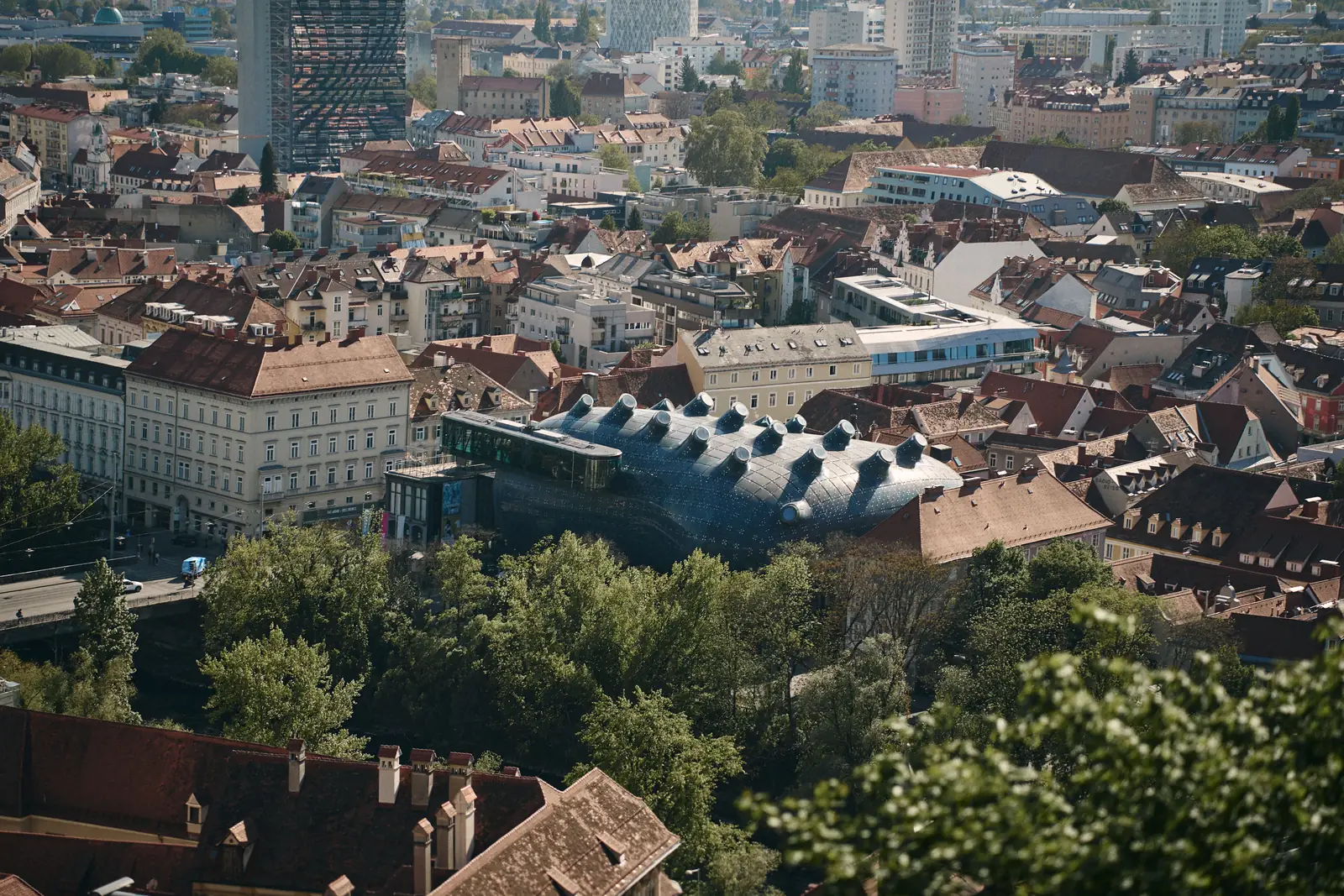 The blue blob shaped Kunsthaus Graz museum sitting among the red rooftops of the old town