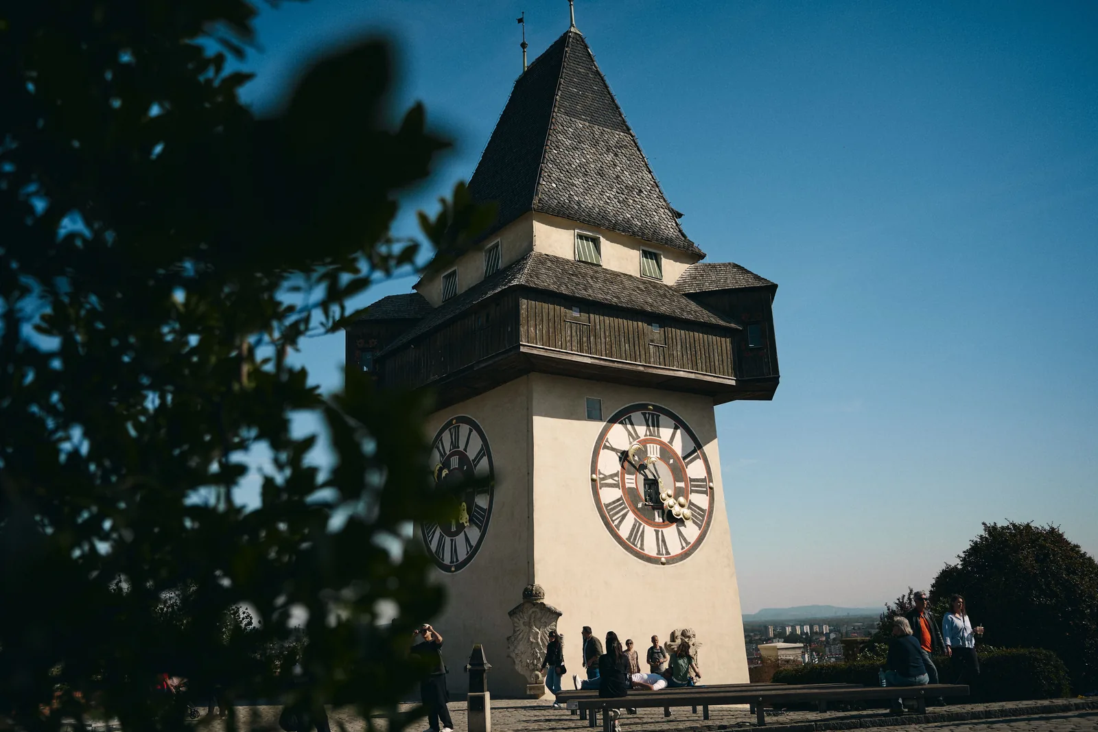 The Uhrturm clock tower on Schlossberg hill in Graz against a blue sky