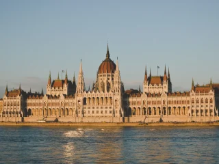 The Hungarian Parliament Building lit by golden evening light across the Danube in Budapest