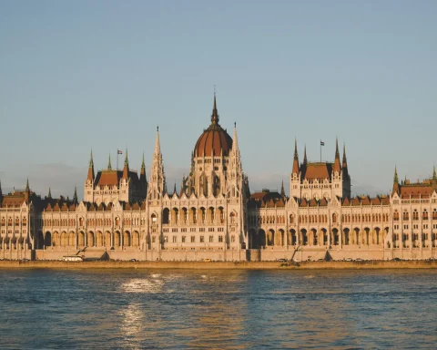 The Hungarian Parliament Building lit by golden evening light across the Danube in Budapest