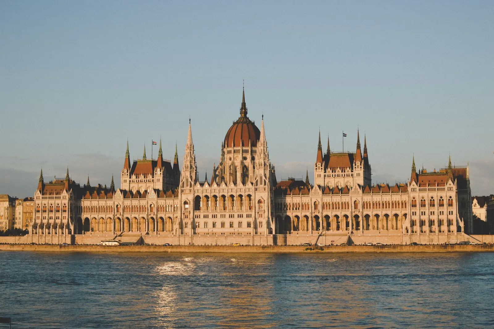 The Hungarian Parliament Building lit by golden evening light across the Danube in Budapest