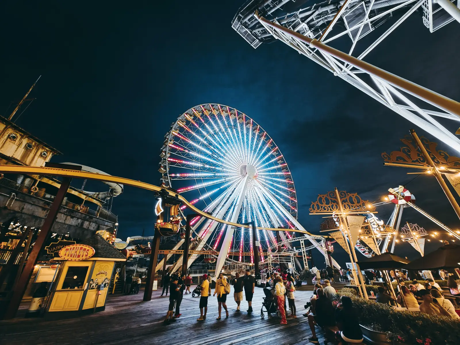 The Ferris wheel and rides lit up at night on the Kemah Boardwalk
