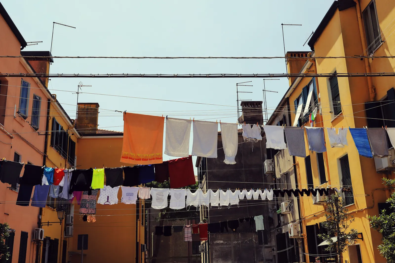 Colorful laundry strung on lines between Italian buildings