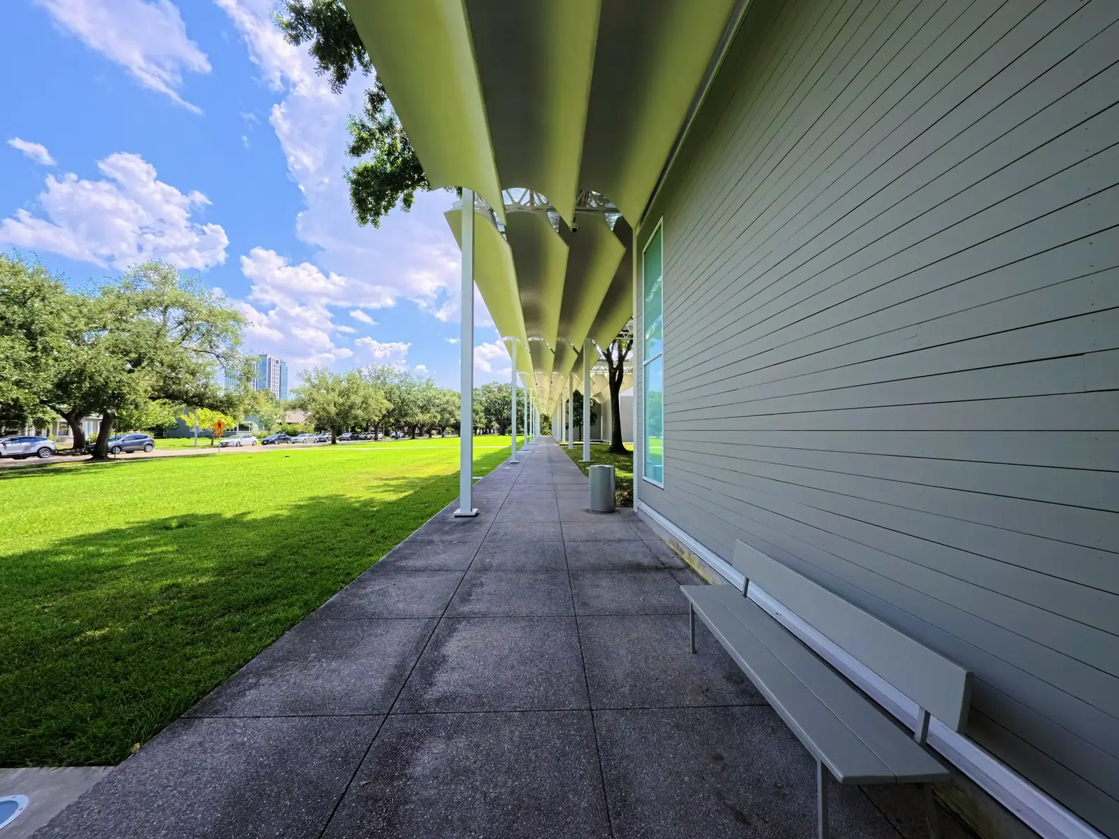 The covered walkway and green lawn outside the Menil Collection in Houston