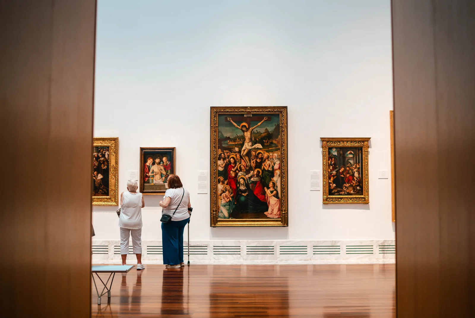 Visitors looking at paintings inside an art museum gallery