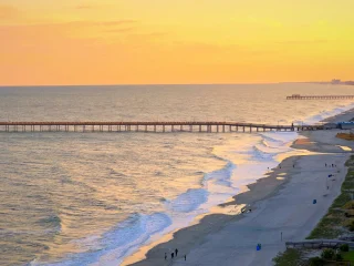 Aerial view of Myrtle Beach at sunset with the pier reaching into the ocean