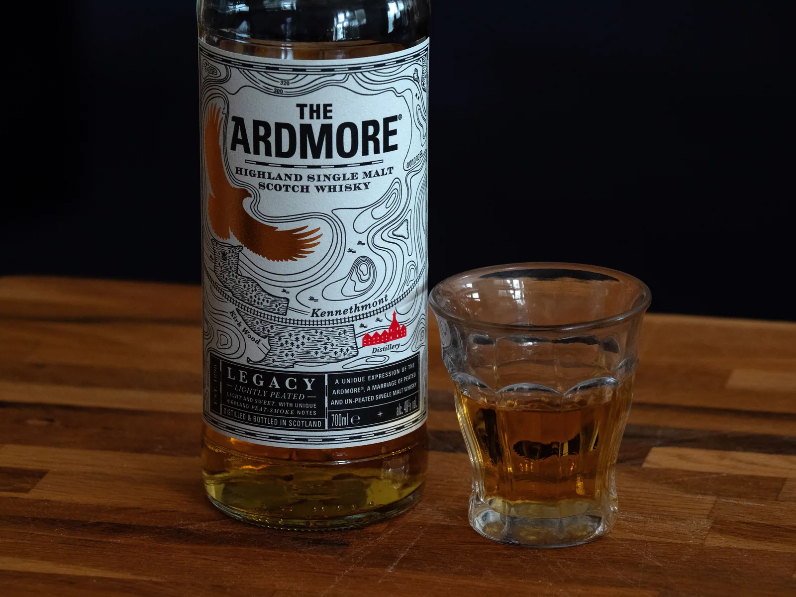 A bottle of Scotch single malt whisky beside a filled tasting glass