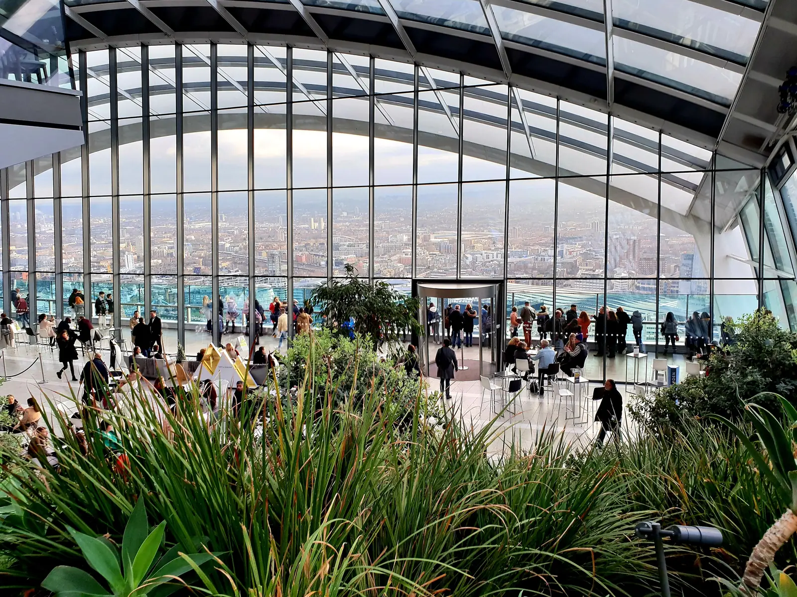 Visitors among the plants at Sky Garden with the city below