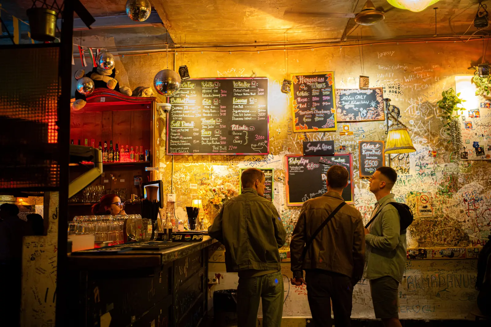 The graffiti covered bar and chalkboard menus inside Szimpla Kert ruin bar in Budapest