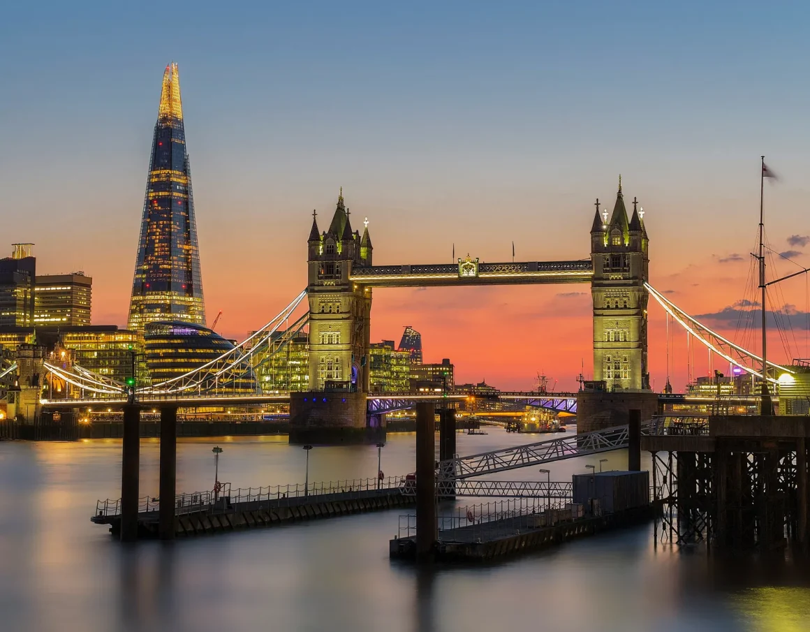 Tower Bridge lit up at sunset with the Shard behind it