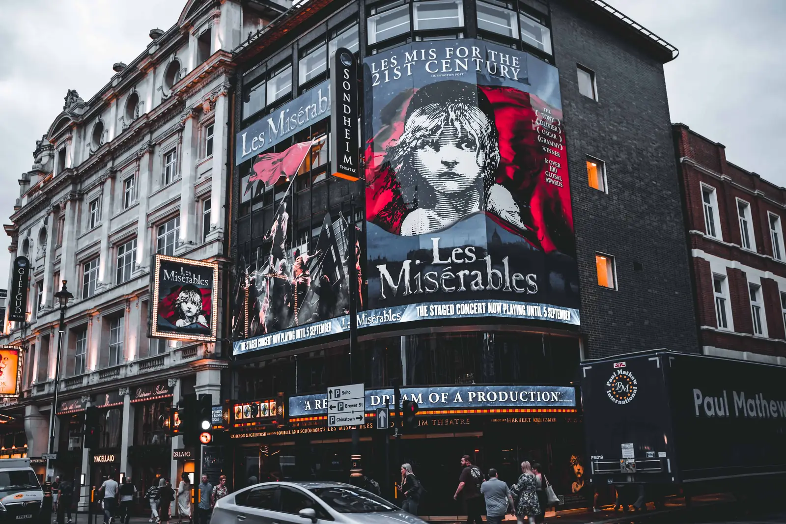 A West End theatre front lit up with a musical billboard