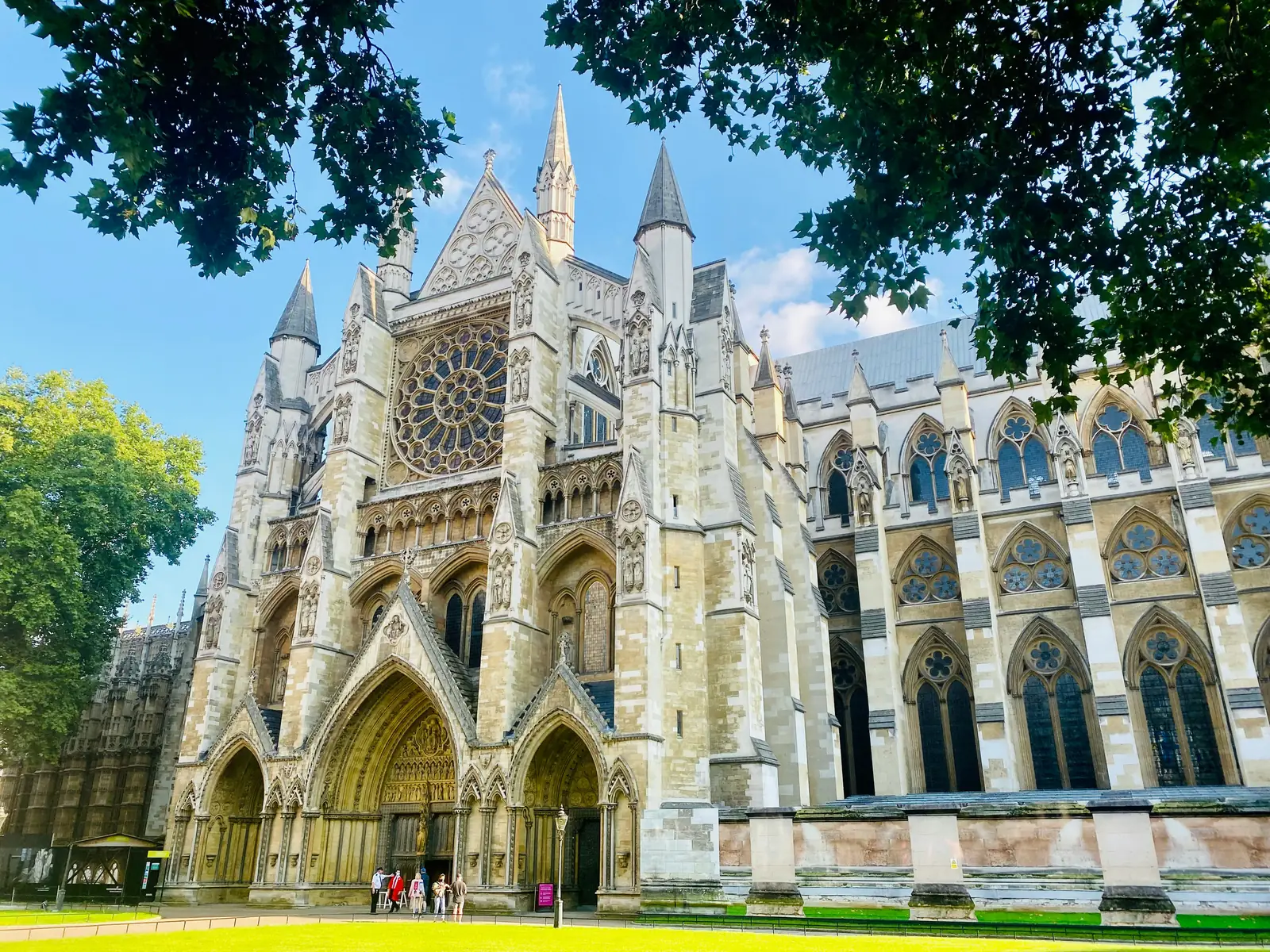 The stone facade of Westminster Abbey framed by trees