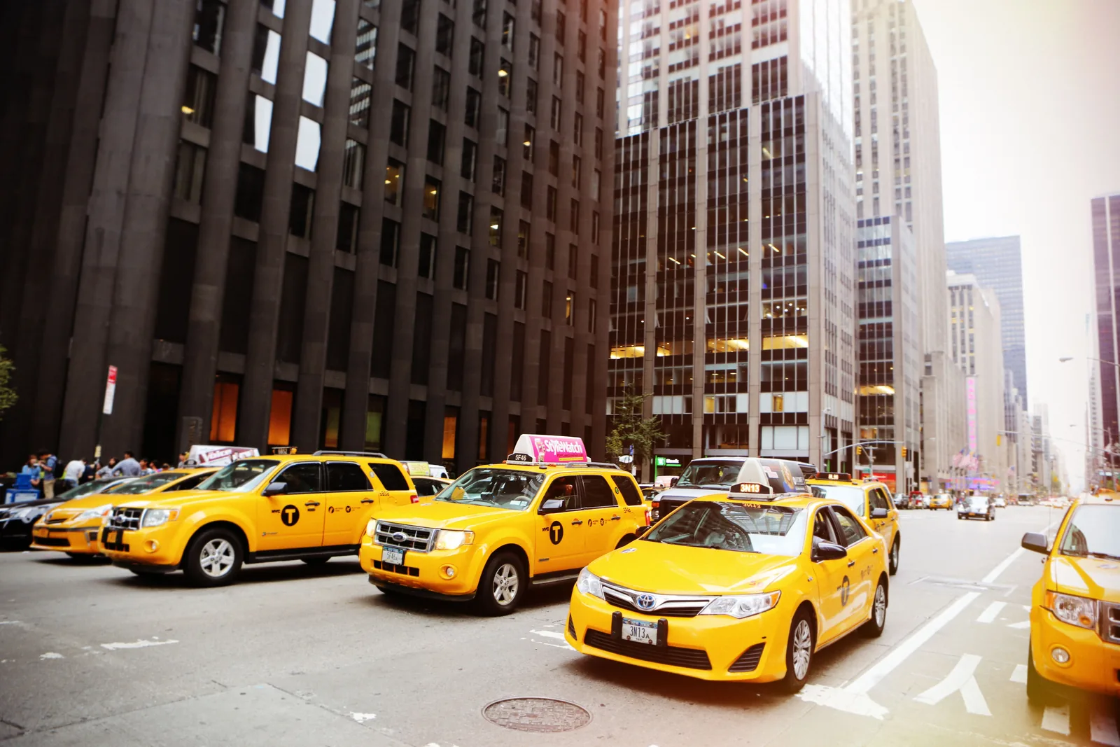 Yellow taxis lined up on a busy New York City street