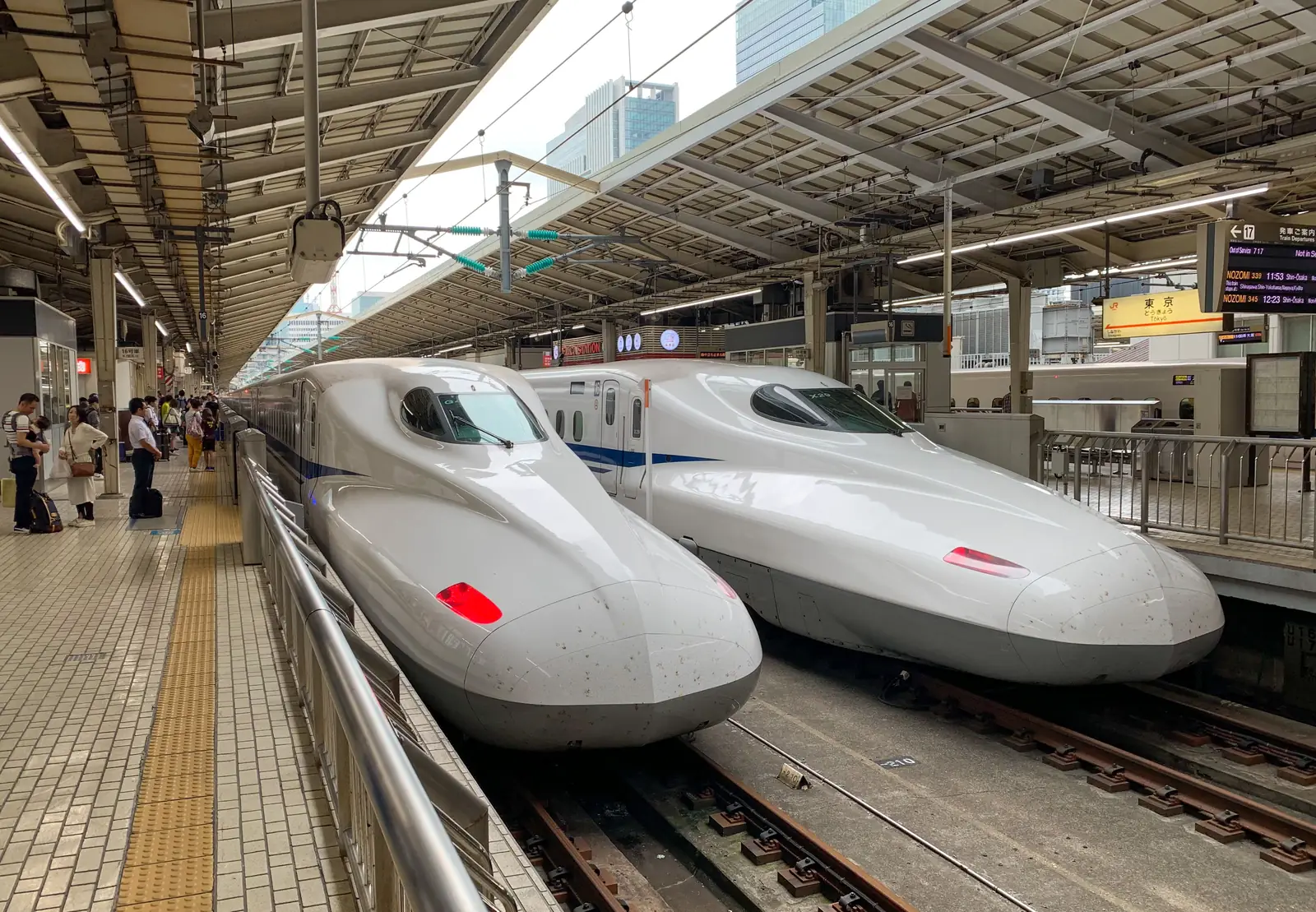 Two shinkansen bullet trains waiting nose to nose at a station platform