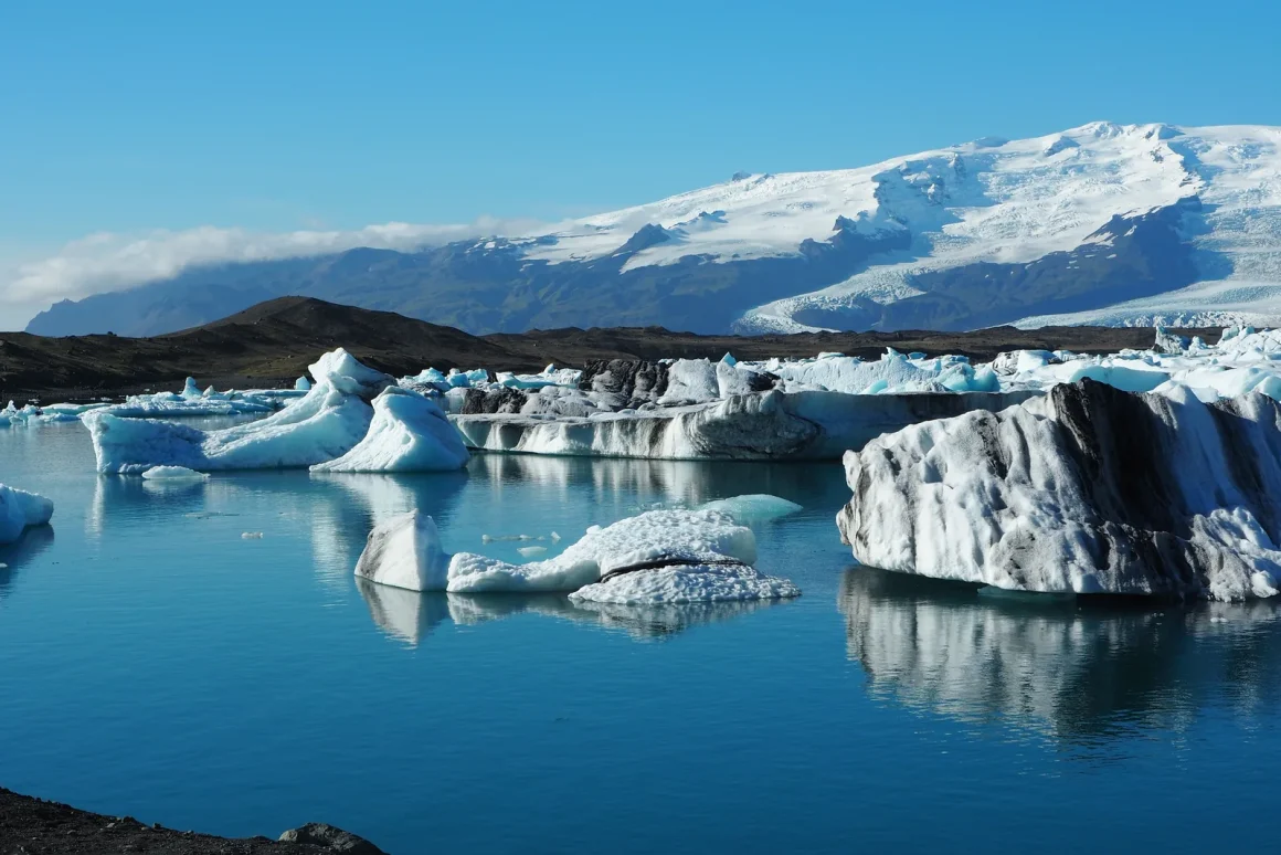Icebergs floating on the still blue water of Jokulsarlon glacier lagoon in Iceland