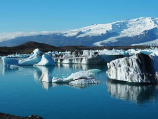 Icebergs floating on the still blue water of Jokulsarlon glacier lagoon in Iceland