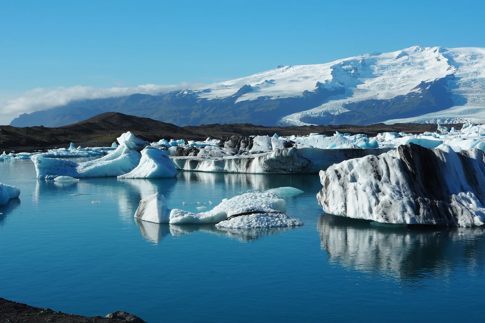 Icebergs floating on the still blue water of Jokulsarlon glacier lagoon in Iceland