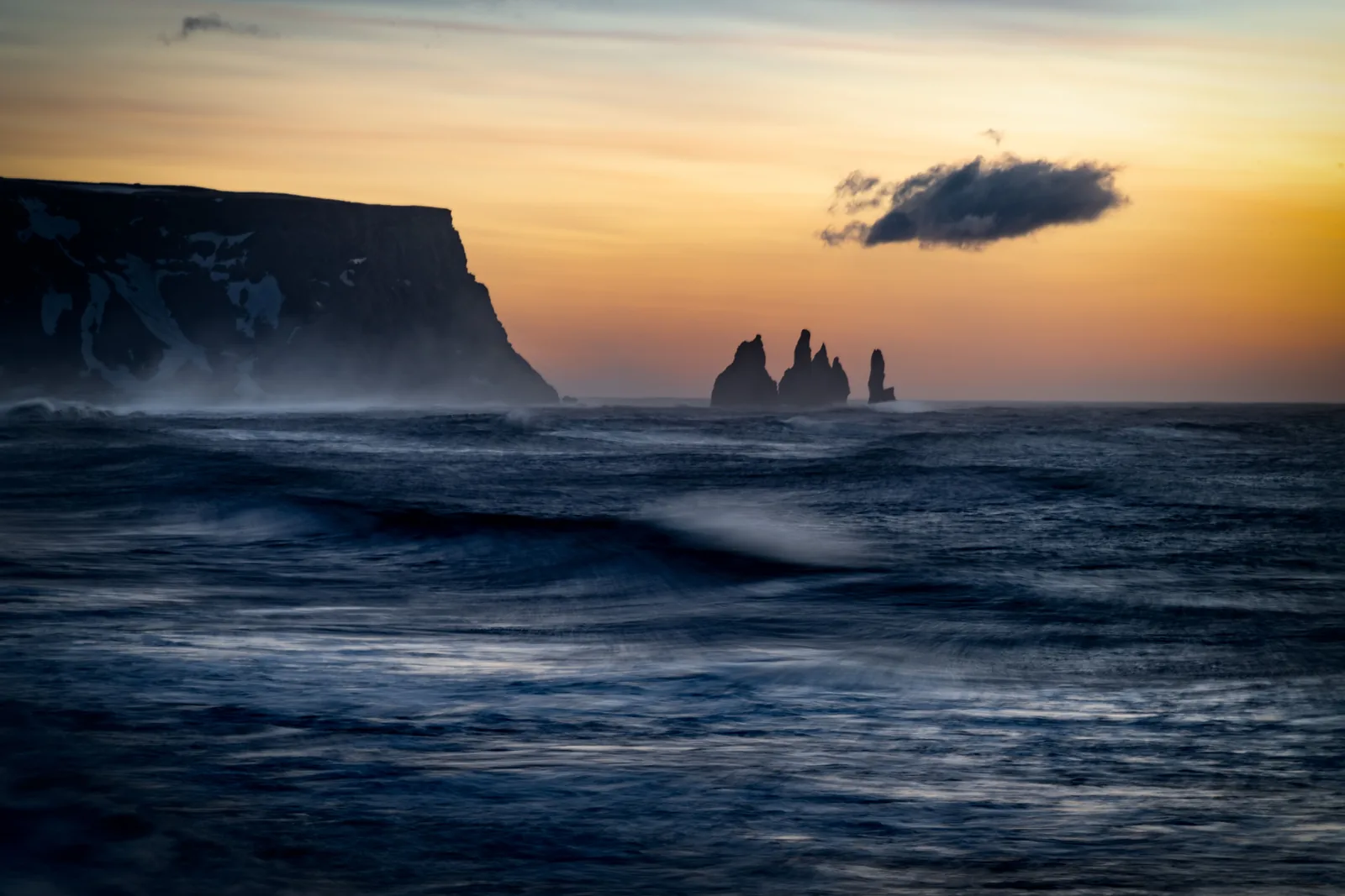 Waves and sea stacks off the black south coast of Iceland at sunset