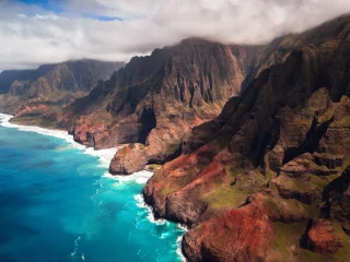 The fluted green cliffs of the Na Pali coast dropping into turquoise water on Kauai