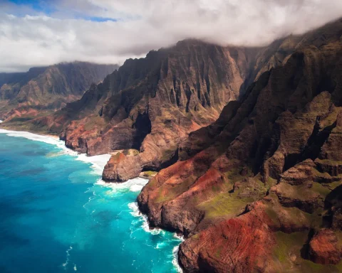The fluted green cliffs of the Na Pali coast dropping into turquoise water on Kauai