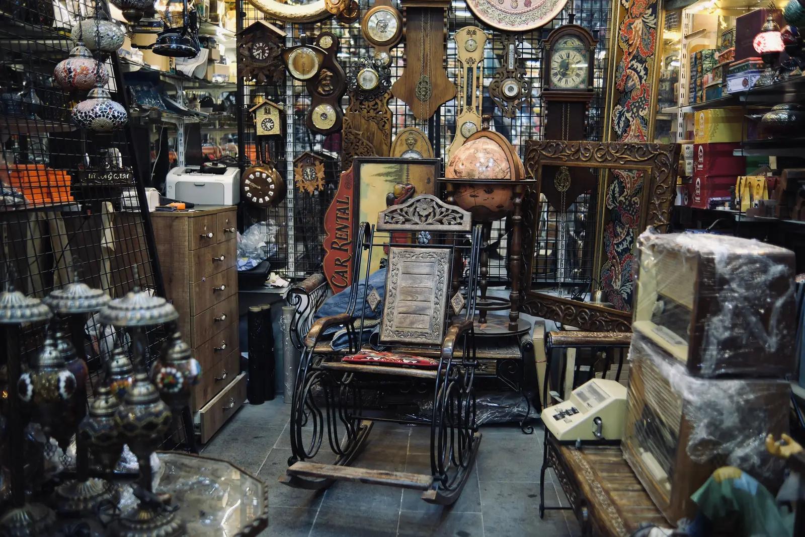 The crowded interior of an antique shop stacked with clocks, lamps and bric a brac