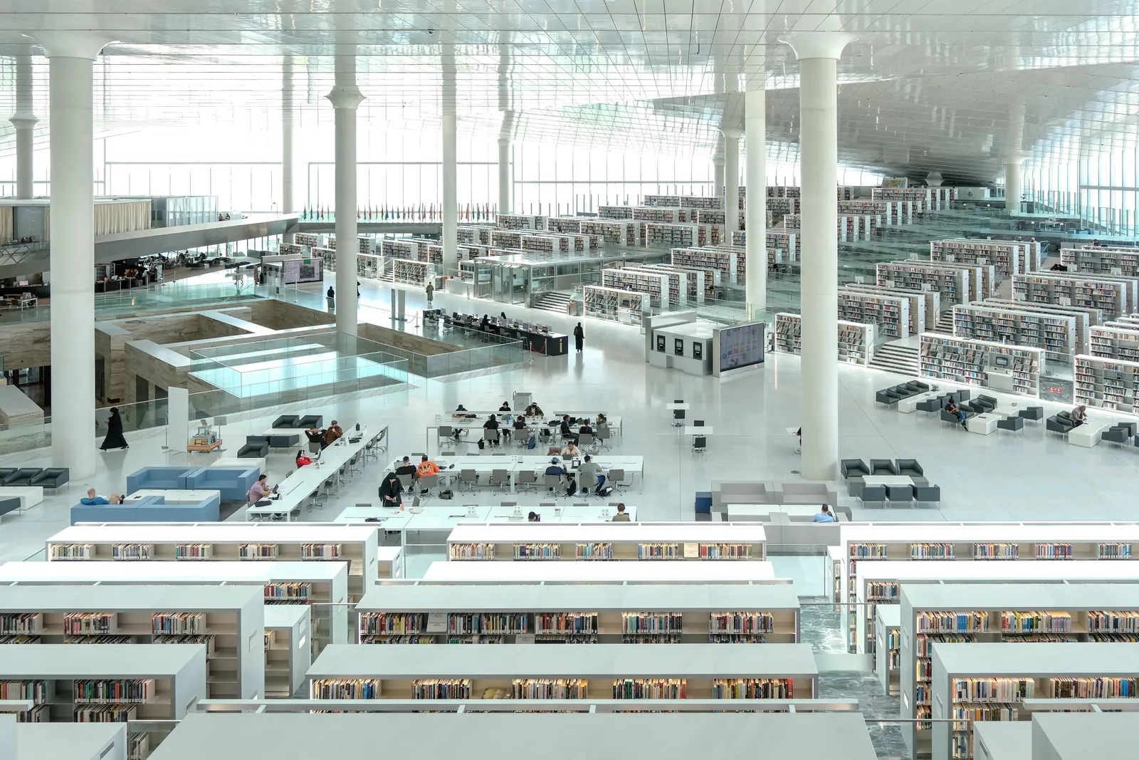 A bright modern library interior with reading desks and tall windows