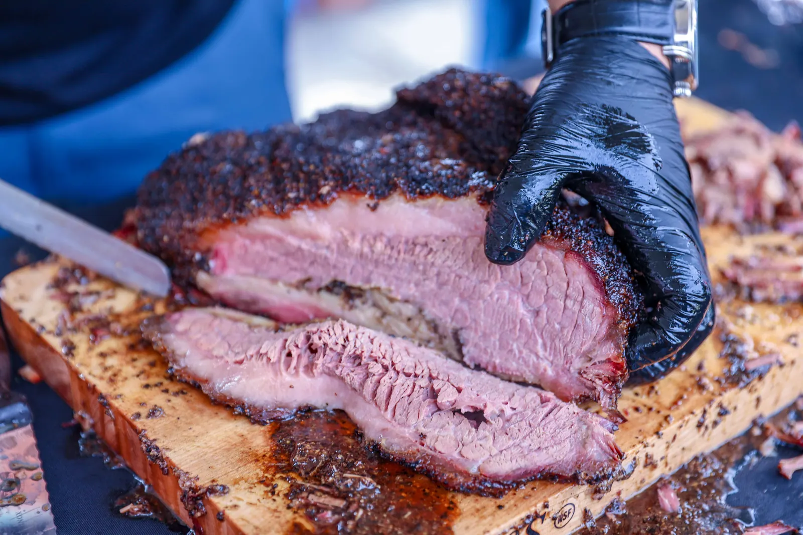 Barbecue brisket being sliced on a board