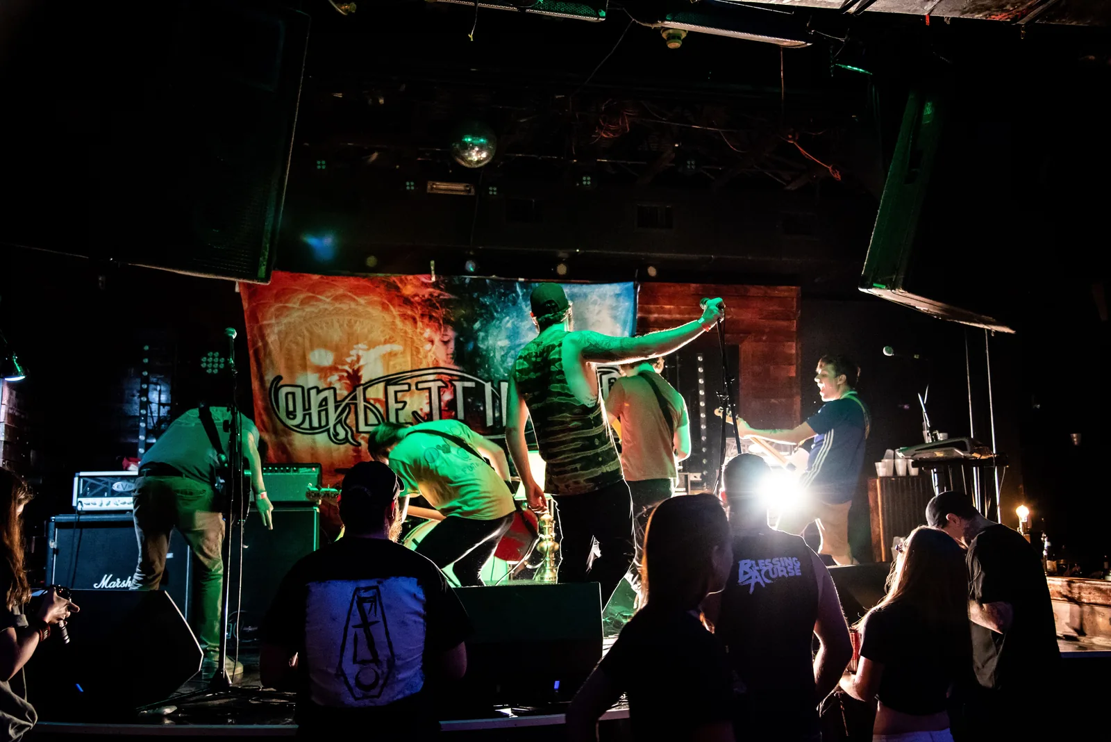 A band playing a small club stage with the crowd right in front