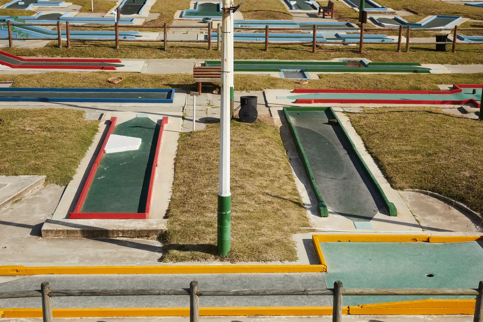 An old mini golf course with worn concrete lanes and painted borders