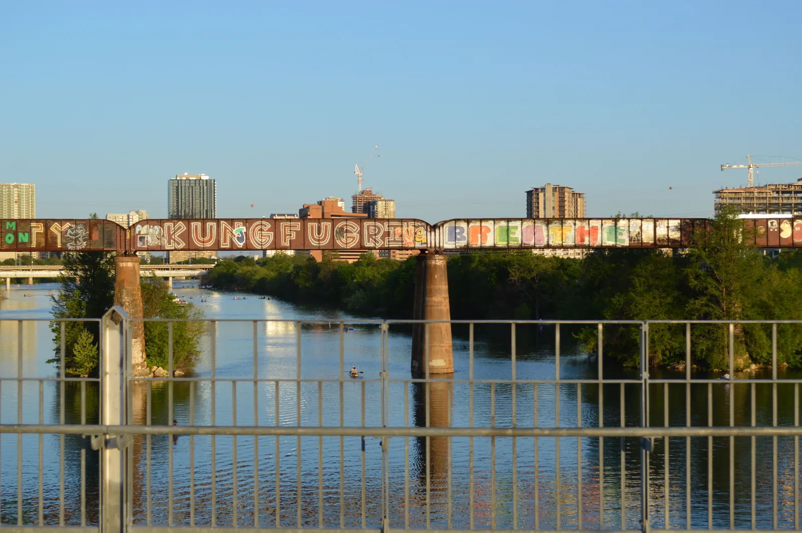 Graffiti covering a rail bridge over Lady Bird Lake in Austin