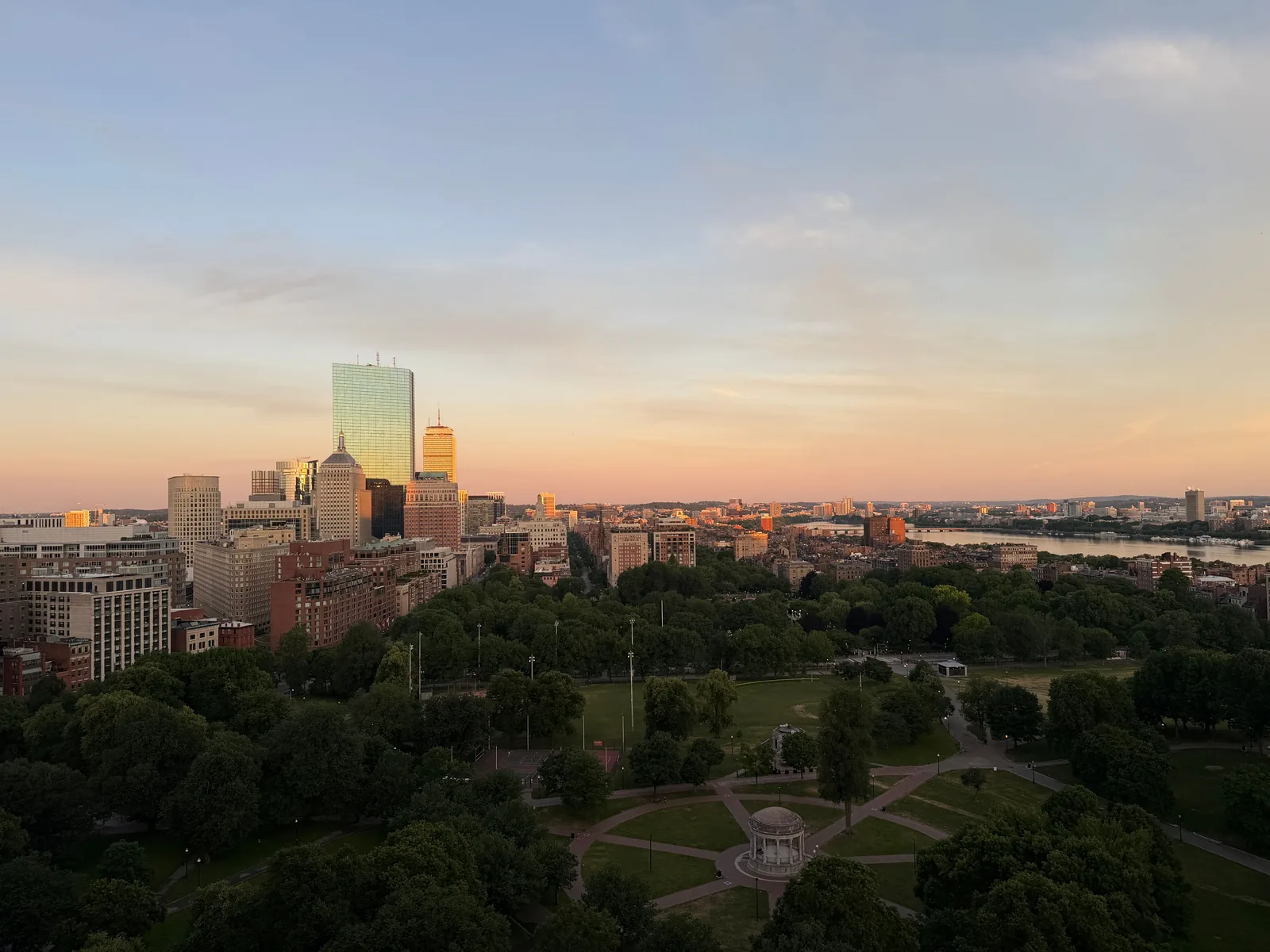 An elevated view over the Boston Common and the city skyline at sunset