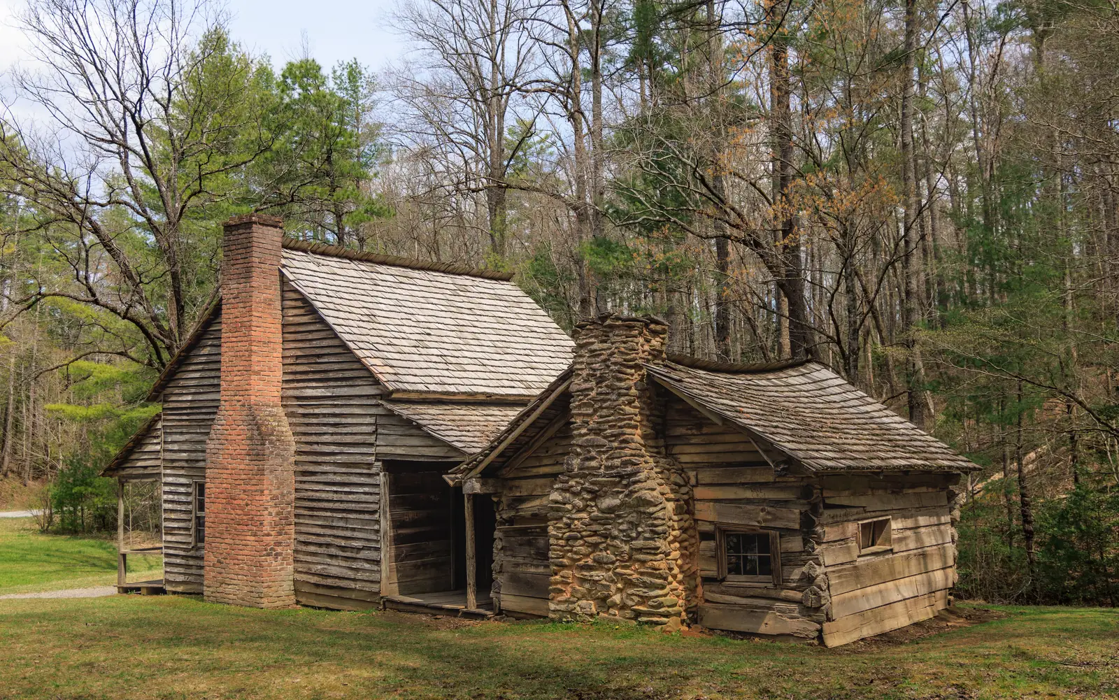 A historic log cabin with a stone chimney in the Tennessee mountains