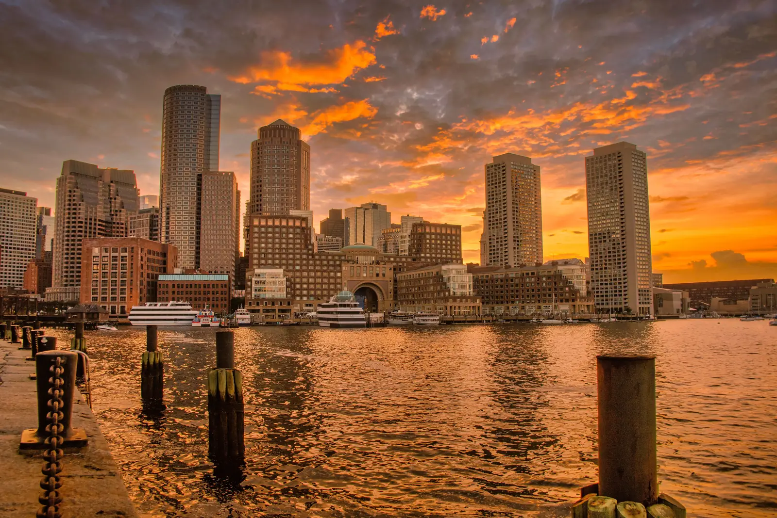 Boston Harbor and the downtown skyline lit orange at sunset