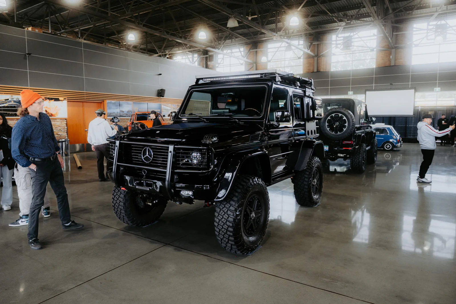 A modern SUV on a display stand at an indoor auto show