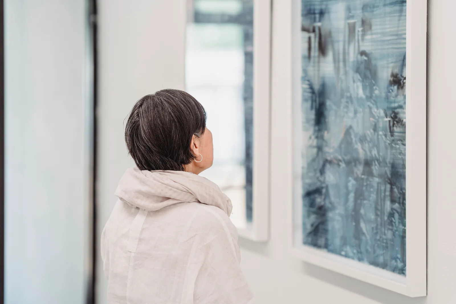 A woman looking at a large abstract painting in a gallery