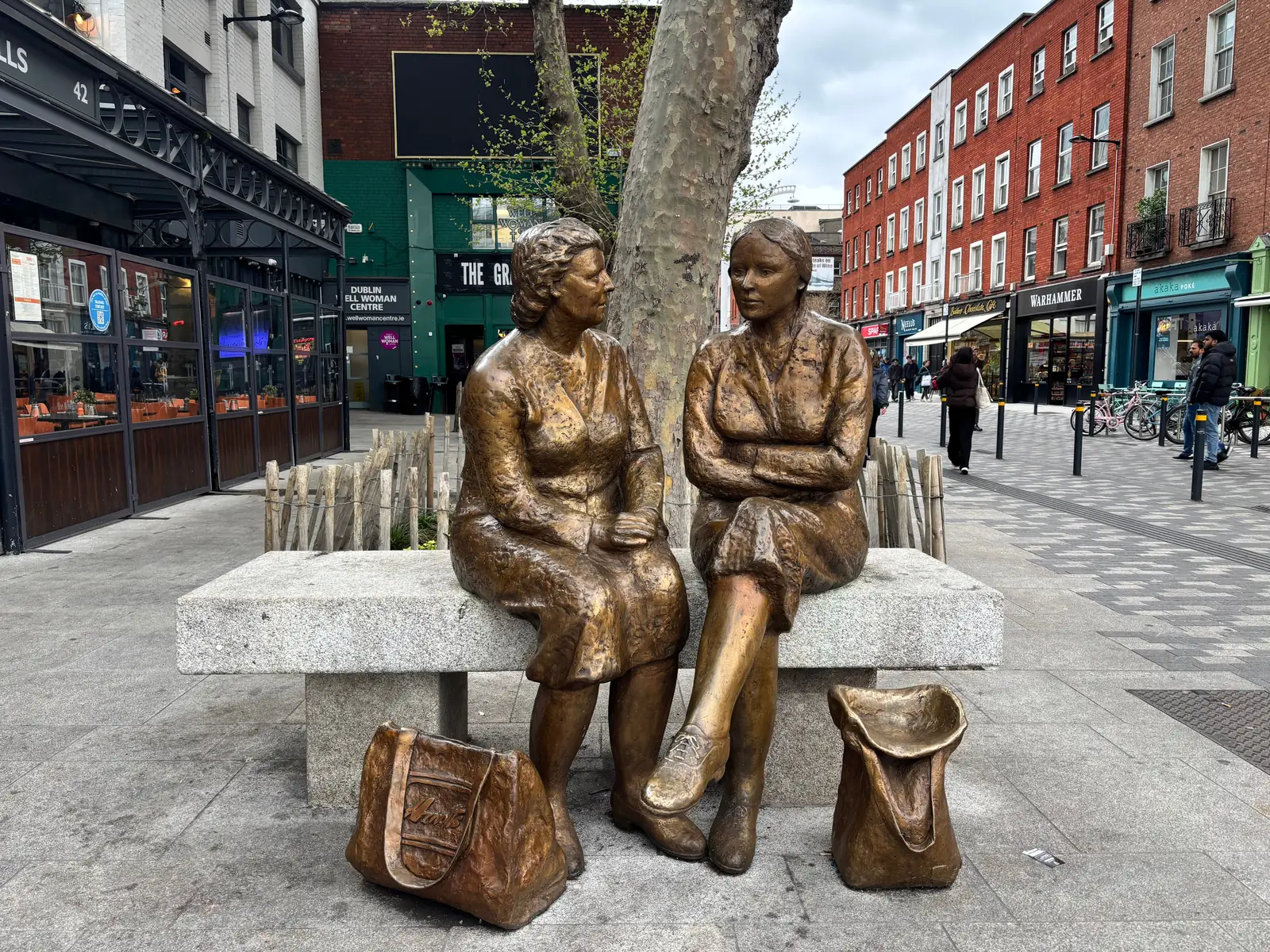Bronze statues of two women resting with their shopping bags on a Dublin street