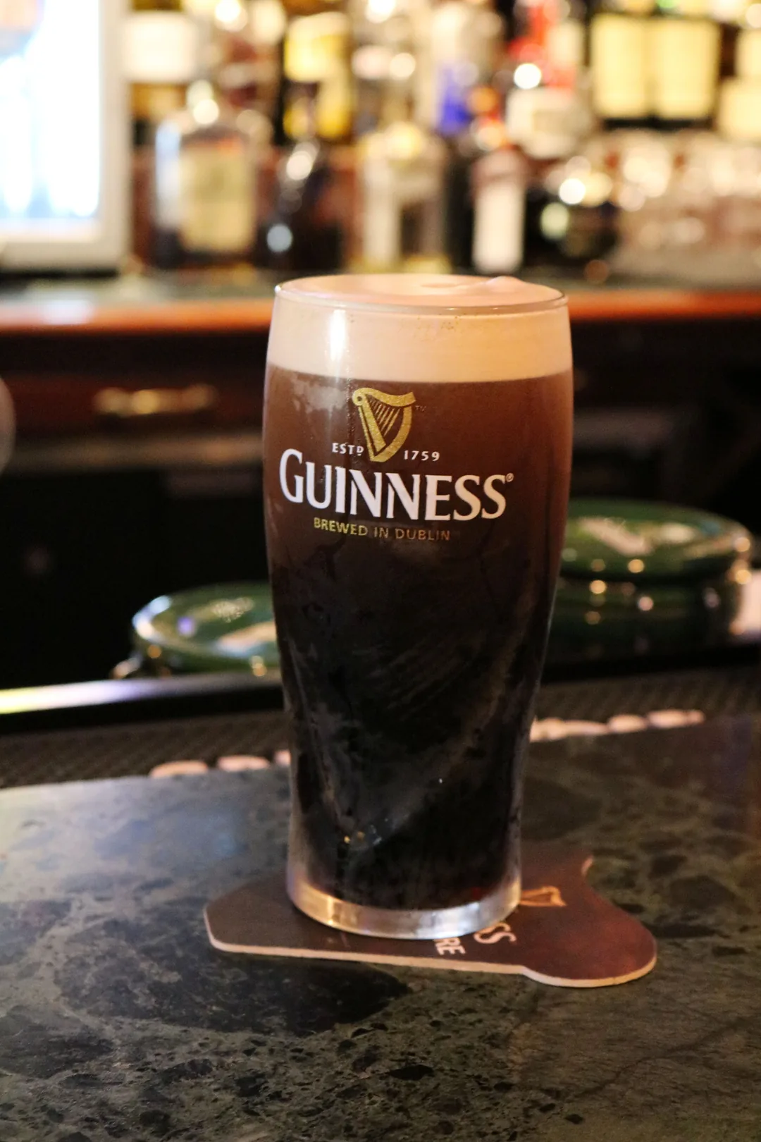 A settled pint of Guinness on a wooden pub counter
