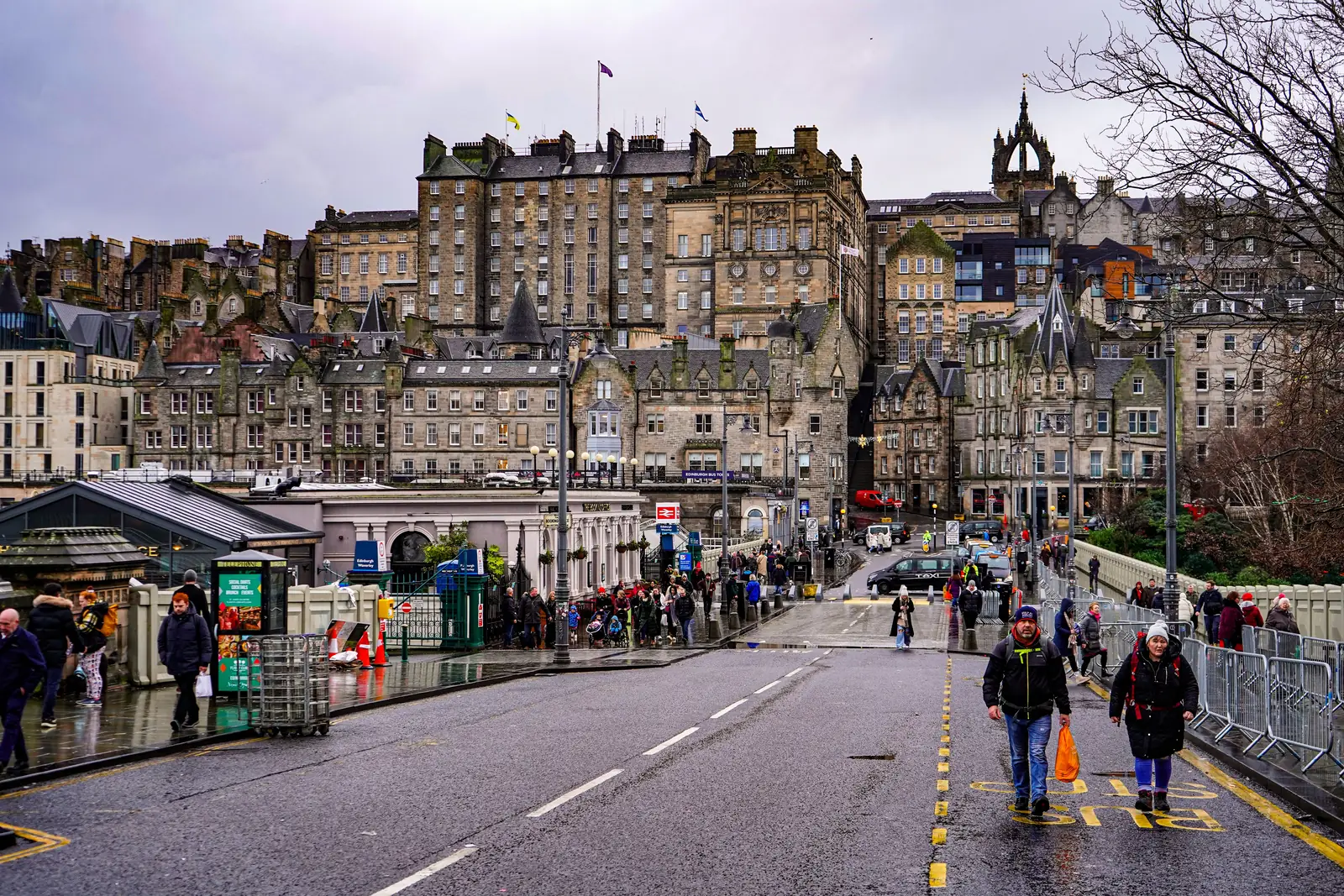 People crossing Waverley Bridge in Edinburgh on a wet day