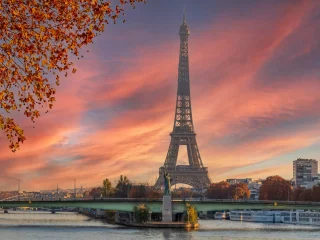 The Eiffel Tower and the river Seine under a pink sunset sky in Paris